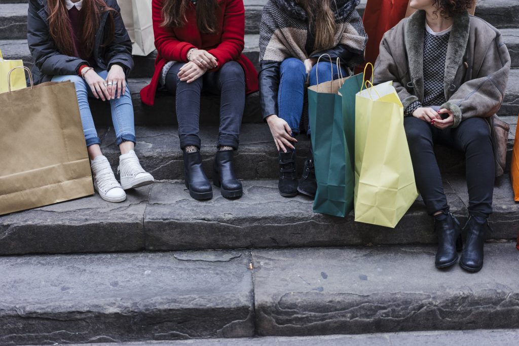 Happy female group of friends doing shopping together