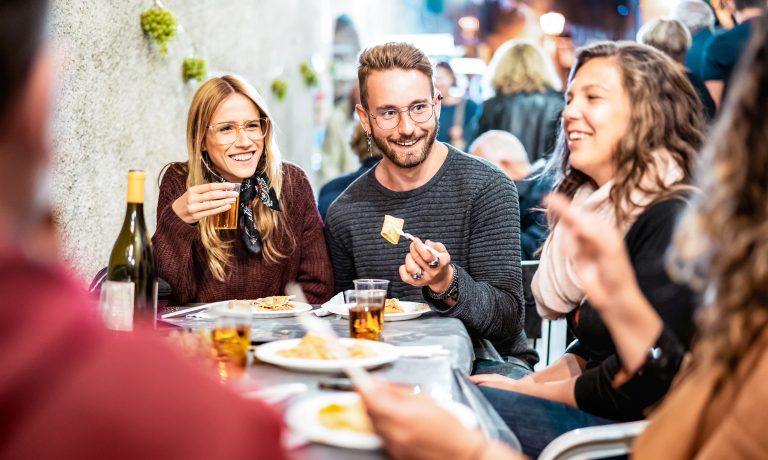 Trendy people having fun drinking white wine at street food event