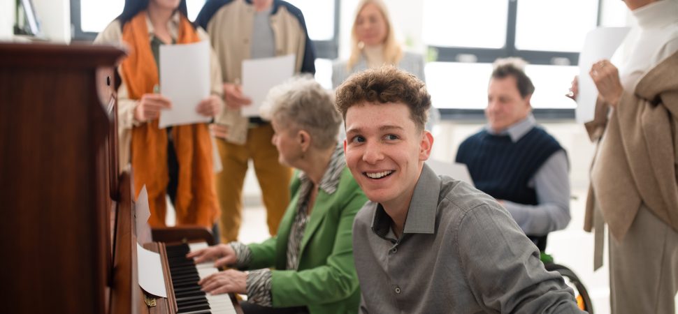 Group of seniors with young teacher singing together at choir rehearsal