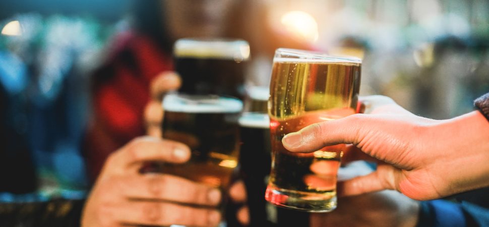 Young group of people having fun cheering with beer outdoor at bar restaurant